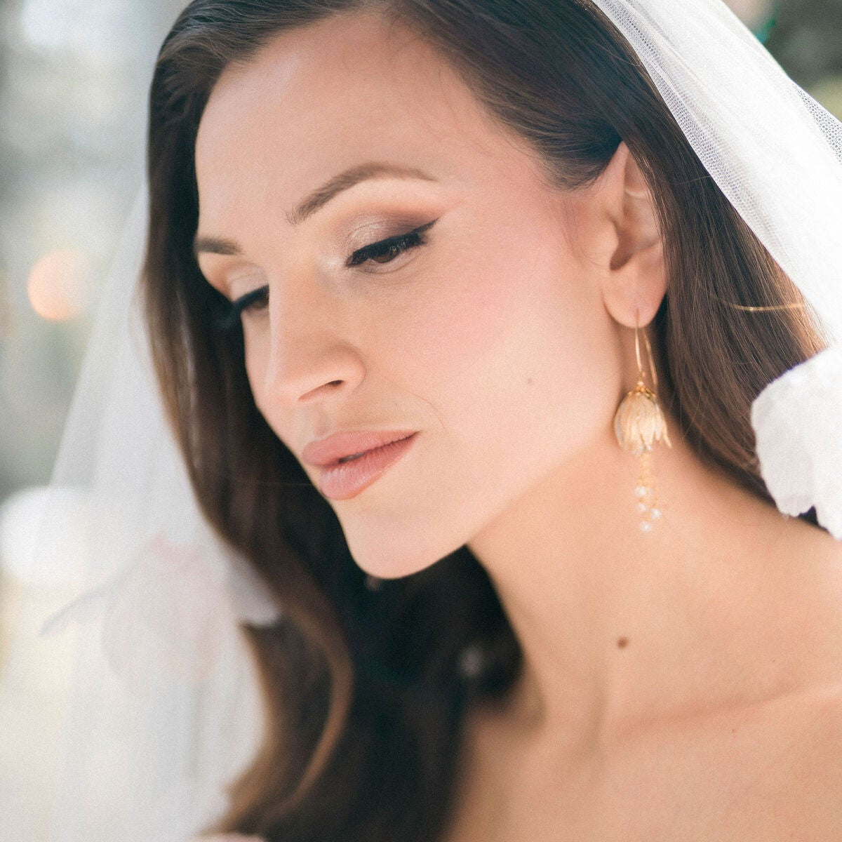 Close-up of a bride wearing a white dress and veil with a blurred background