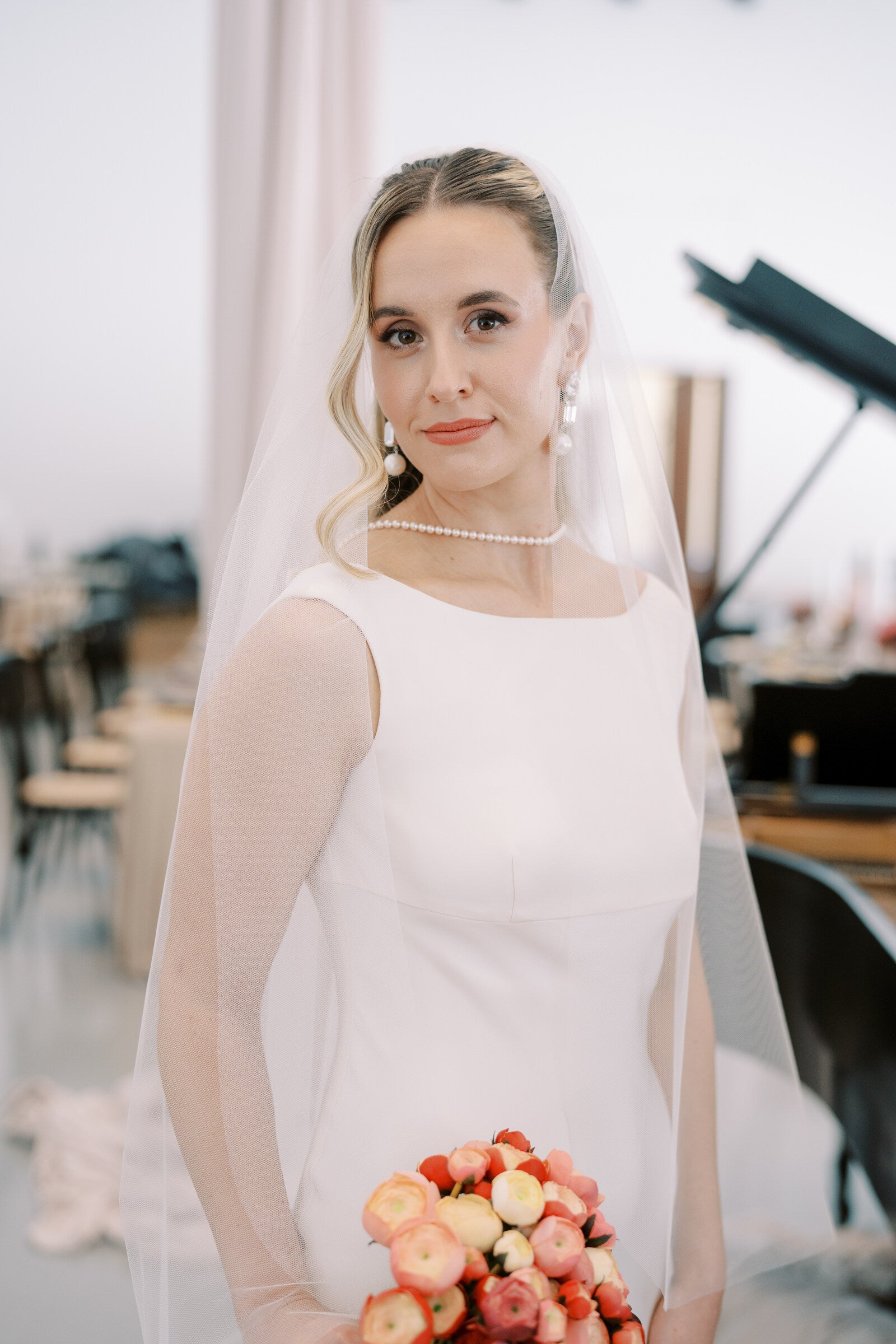 Bride holding a bouquet indoors with a blurred background