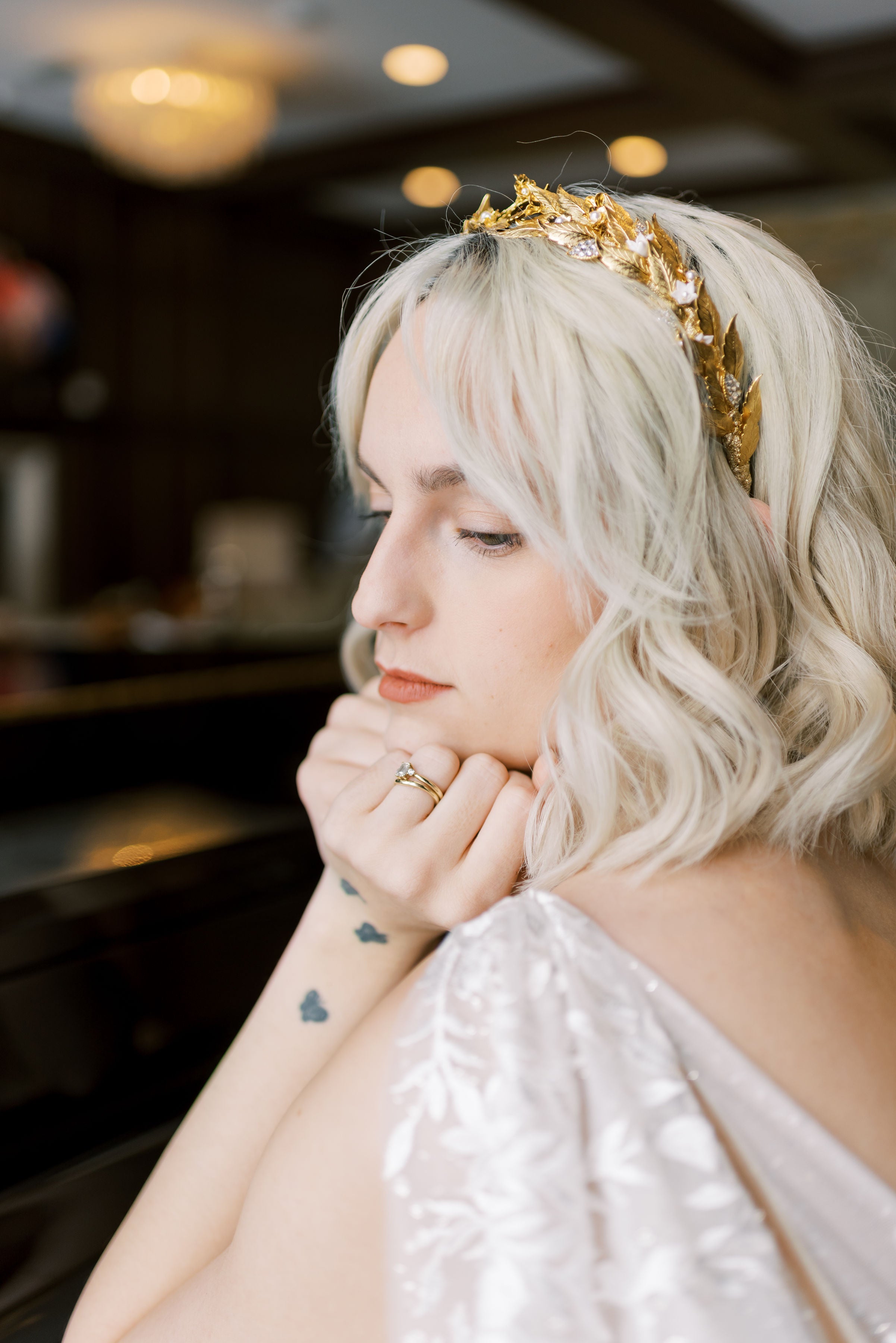 Woman with blonde hair and a gold headpiece in an indoor setting