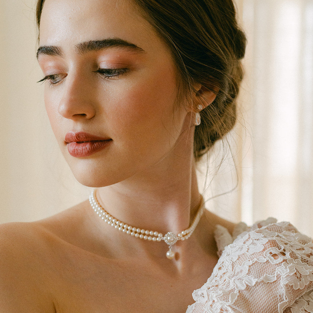 Woman wearing a pearl necklace and lace dress indoors