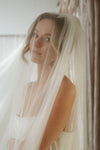 Woman wearing a veil indoors with a neutral background