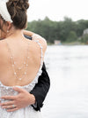 Back view of a bride in a wedding dress with a lake and trees in the background in Muskoka Canada
