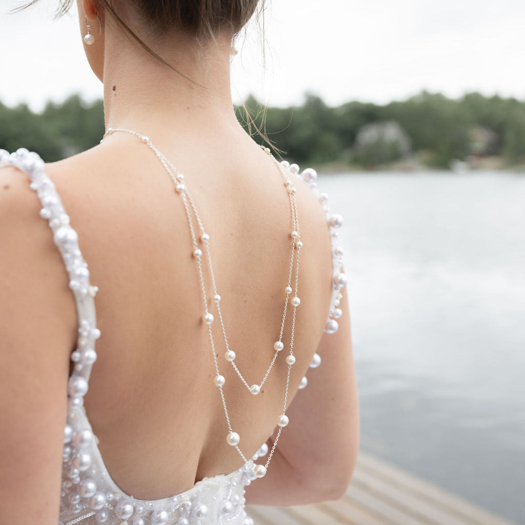 Woman wearing a white dress with pearl back necklace in Muskoka