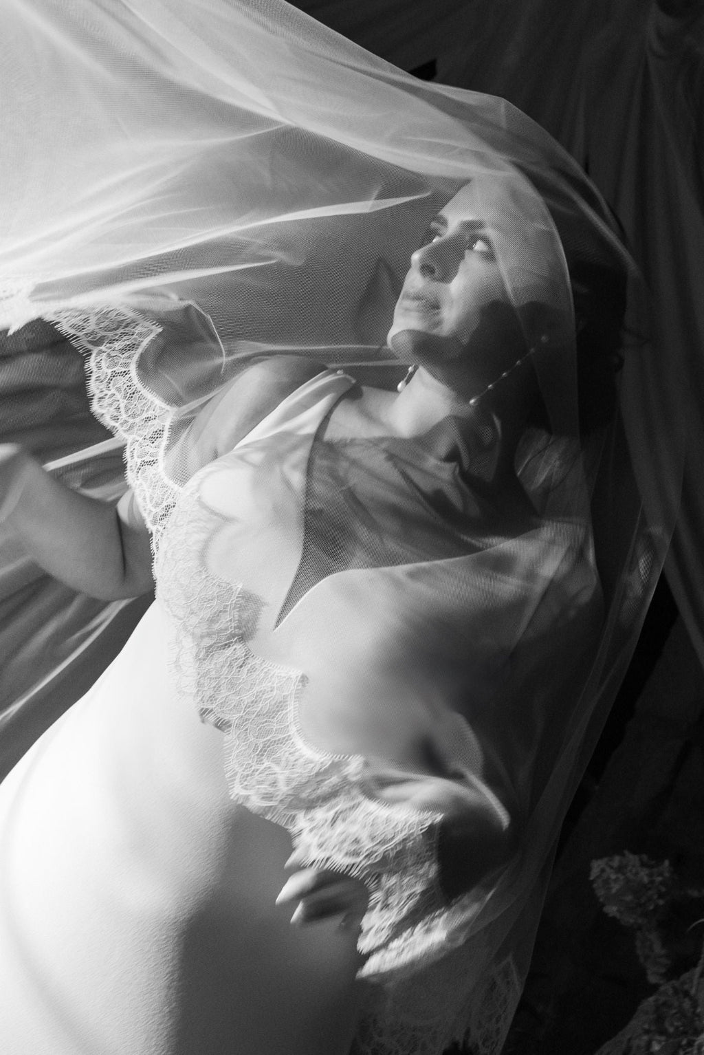Black and white photo of a woman in a wedding dress with a veil.