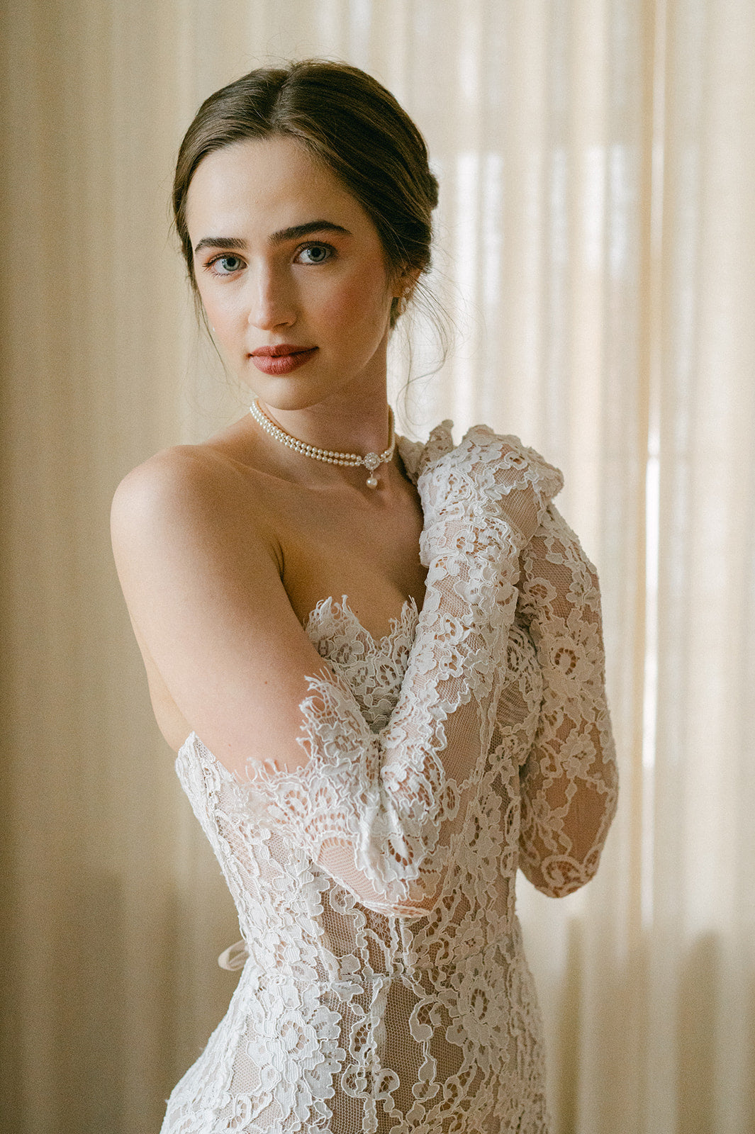 Woman wearing a lace wedding dress with a soft background