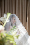 Person wearing a veil with floral decorations in the foreground