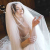 Bride in a wedding dress with a veil indoors.