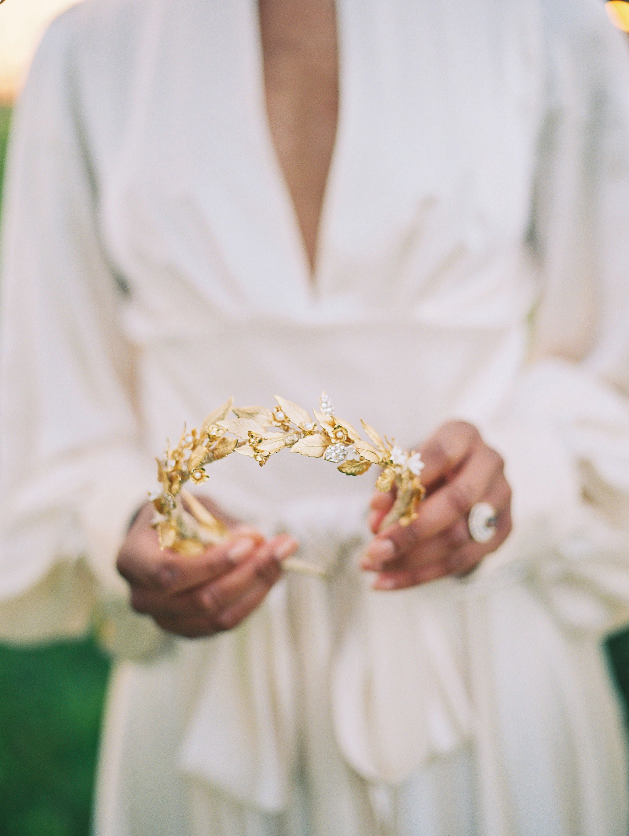Person holding a gold tiara with a blurred background