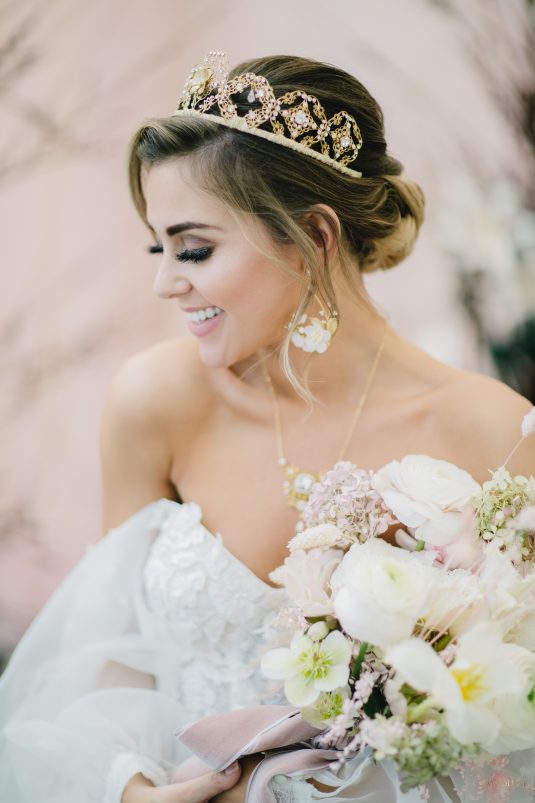 Bride holding a bouquet with a blurred floral background