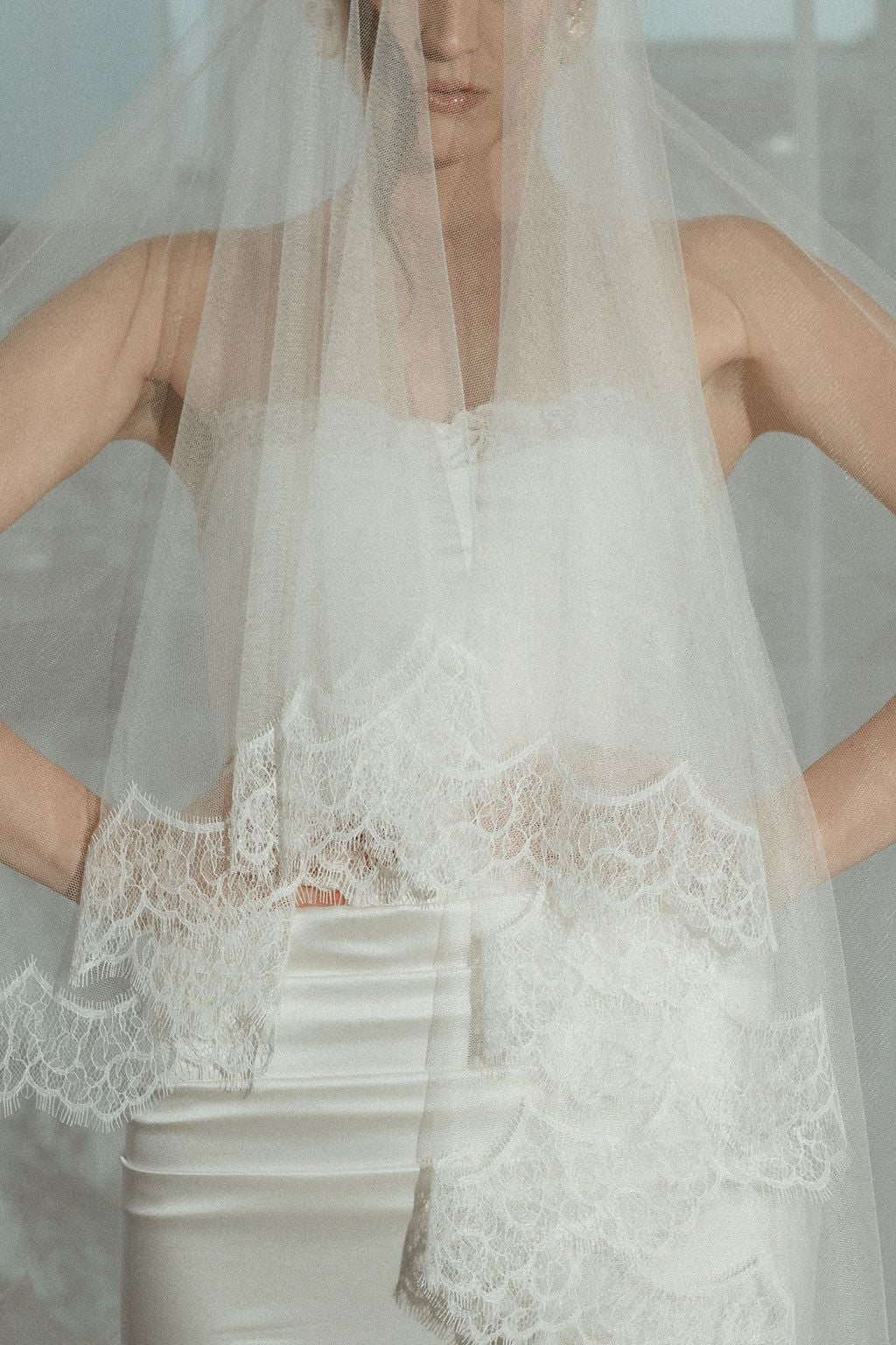 Close-up of a lace-trimmed wedding dress with a veil.