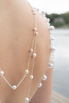 close up of a bride wearing a white dress with pearl back necklace in Muskoka