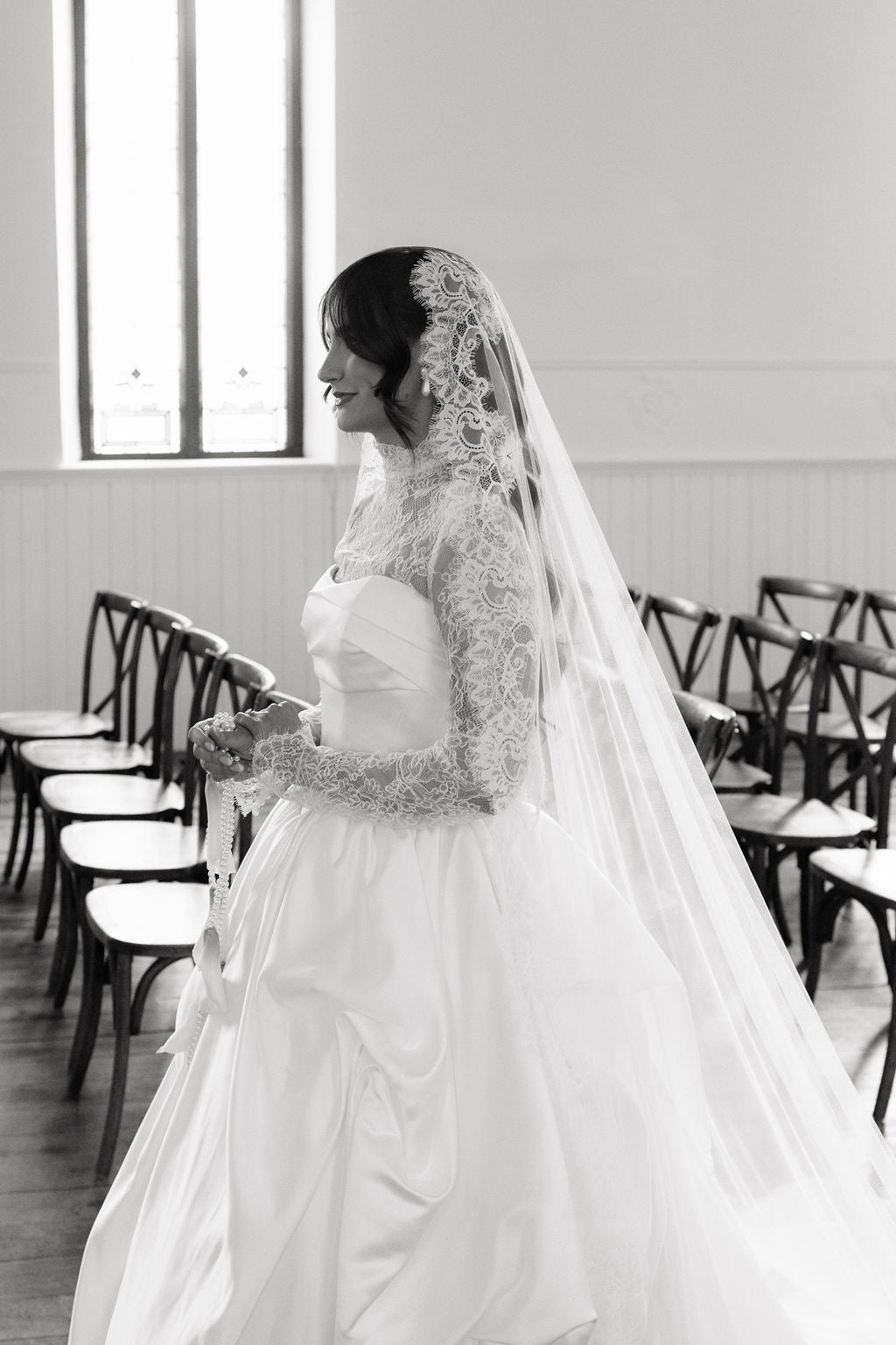 Black and white photo of a bride in a church setting