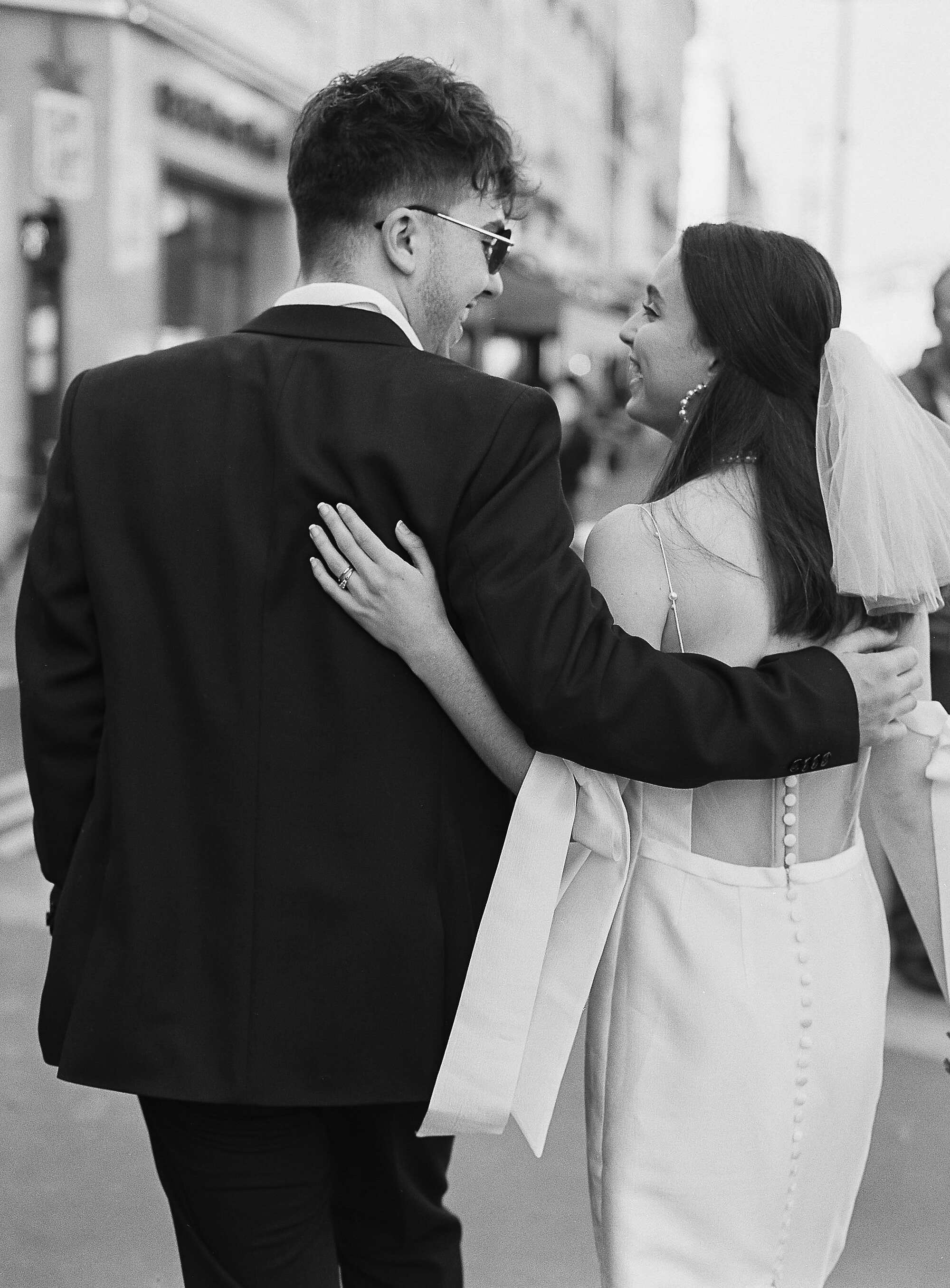 Black and white photo of a couple embracing on a city street.