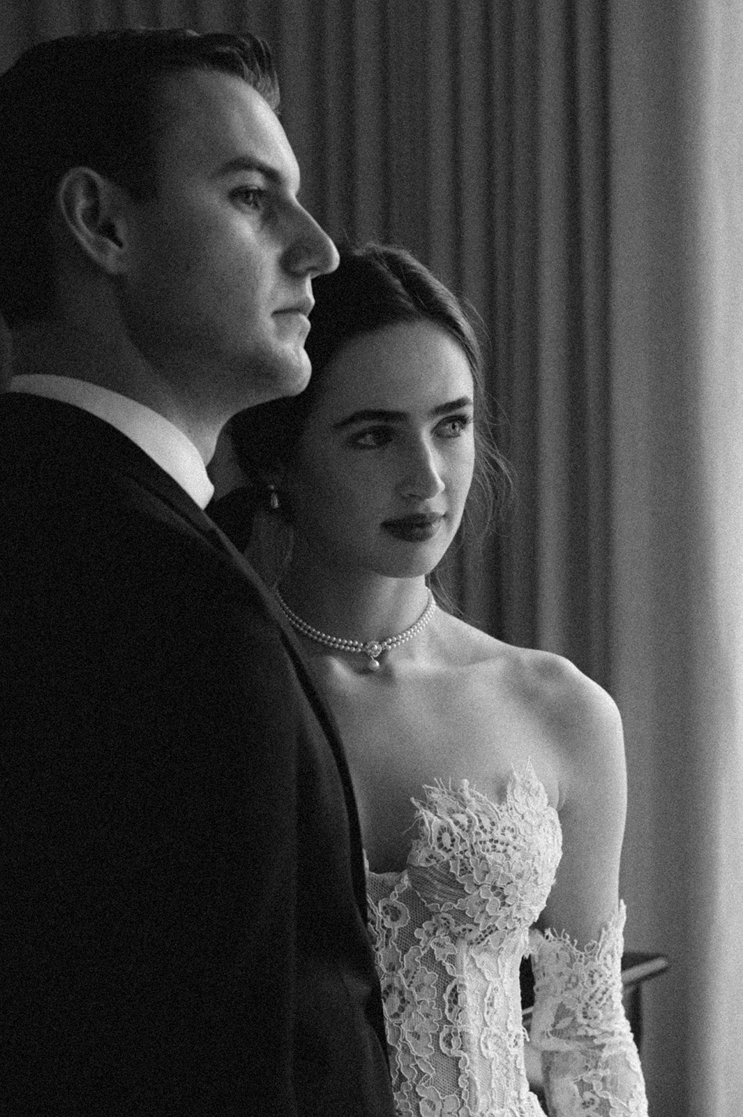 Black and white photo of a couple in formal attire, likely at a wedding.