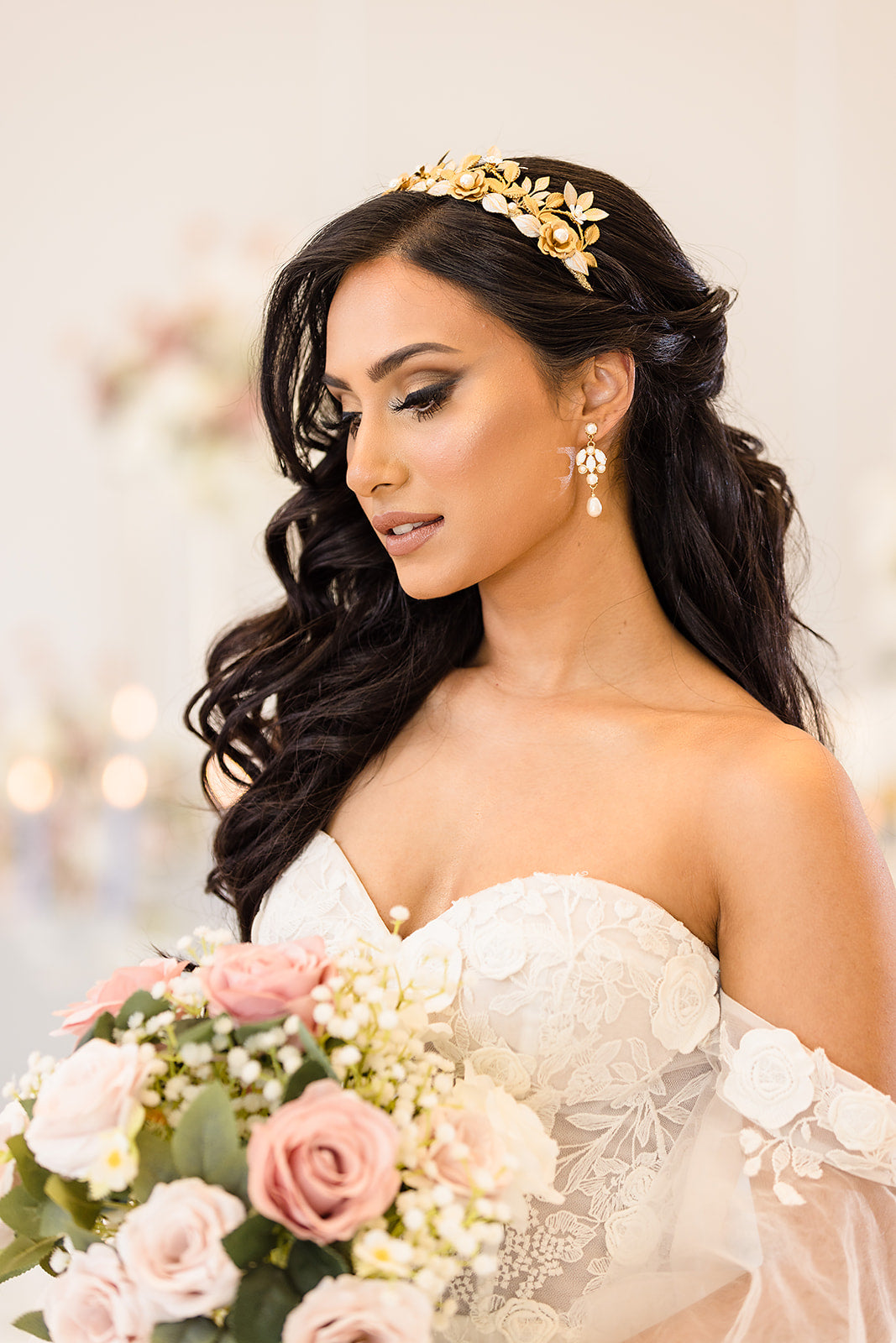 Bride with floral headpiece and bouquet in a softly blurred indoor setting