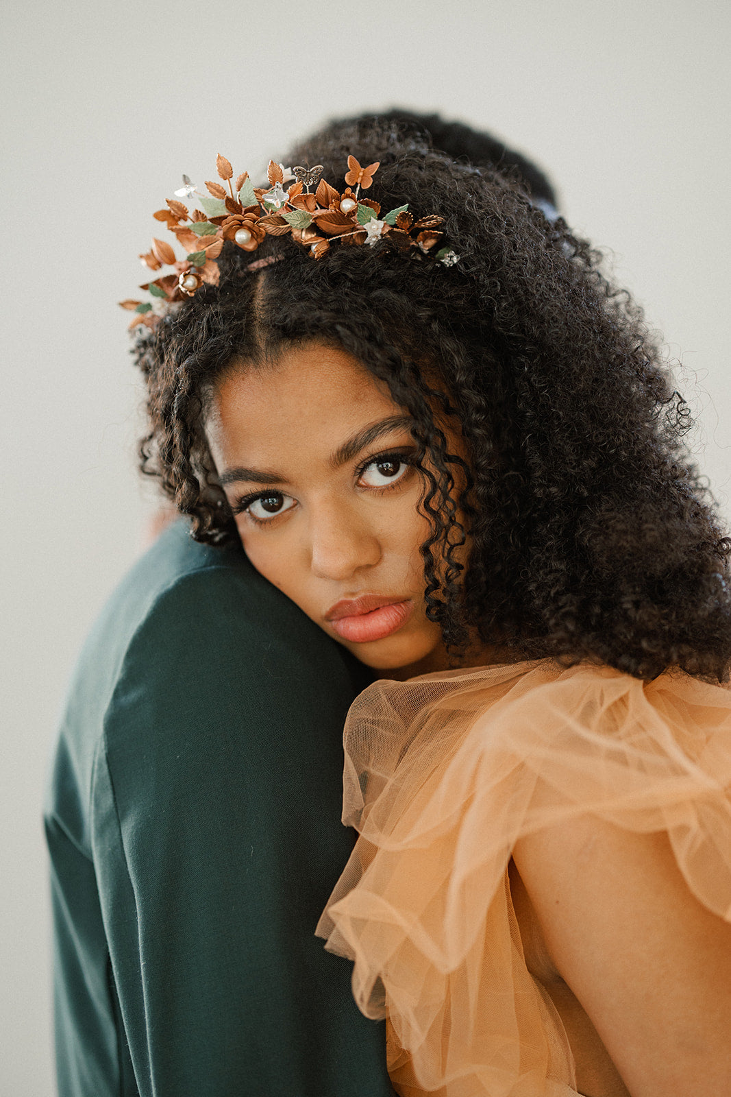 Woman wearing a floral headpiece with a plain background
