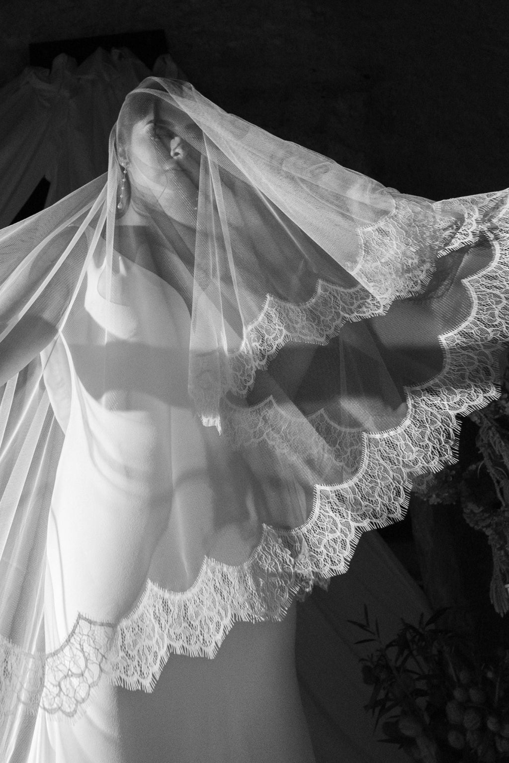 Black and white photo of a person wearing a lace veil.