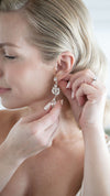 Woman adjusting a sparkling earring on her ear