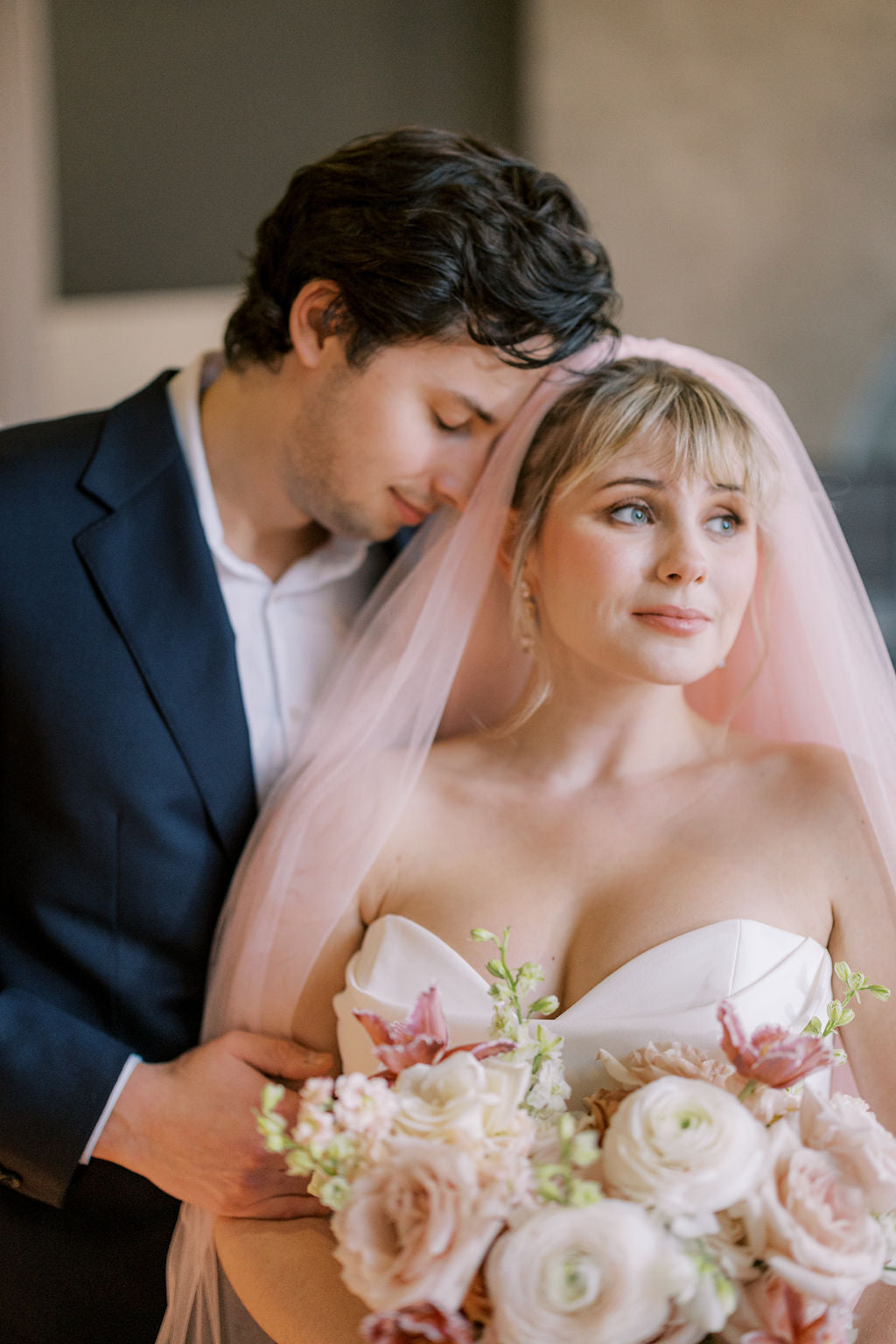 Couple on their wedding day with the woman holding a bouquet of flowers.