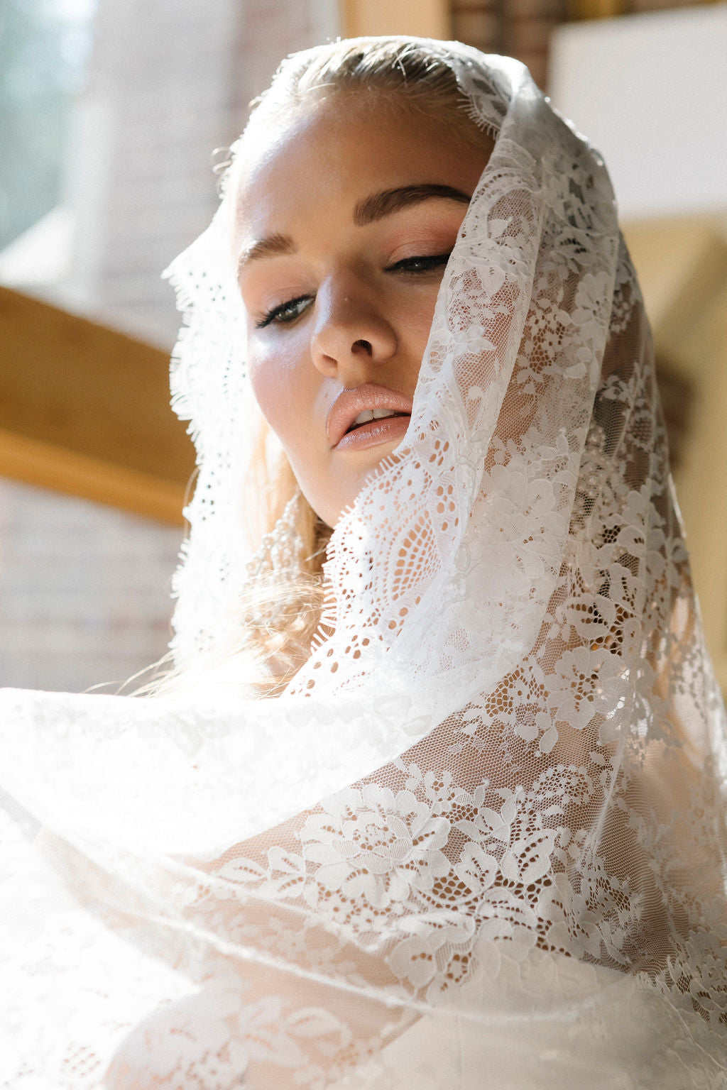Woman wearing a lace veil in an indoor setting