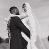 Black and white photo of a bride and groom embracing outdoors.