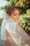 hand embellished scattered pearl bridal veil in a mantilla shape with heavy pearls at top of veil to lighter at bottom. handmade in toronto canada by blair nadeau bridal adornments
