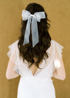 ivory bridal hair bow with hand placed pearls in various sizes at the tail of the bow. Double layered and finished with a comb. This beautiful hair bow can be worn over top of a veil or on its own for a beautiful modern bridal look. made in toronto
