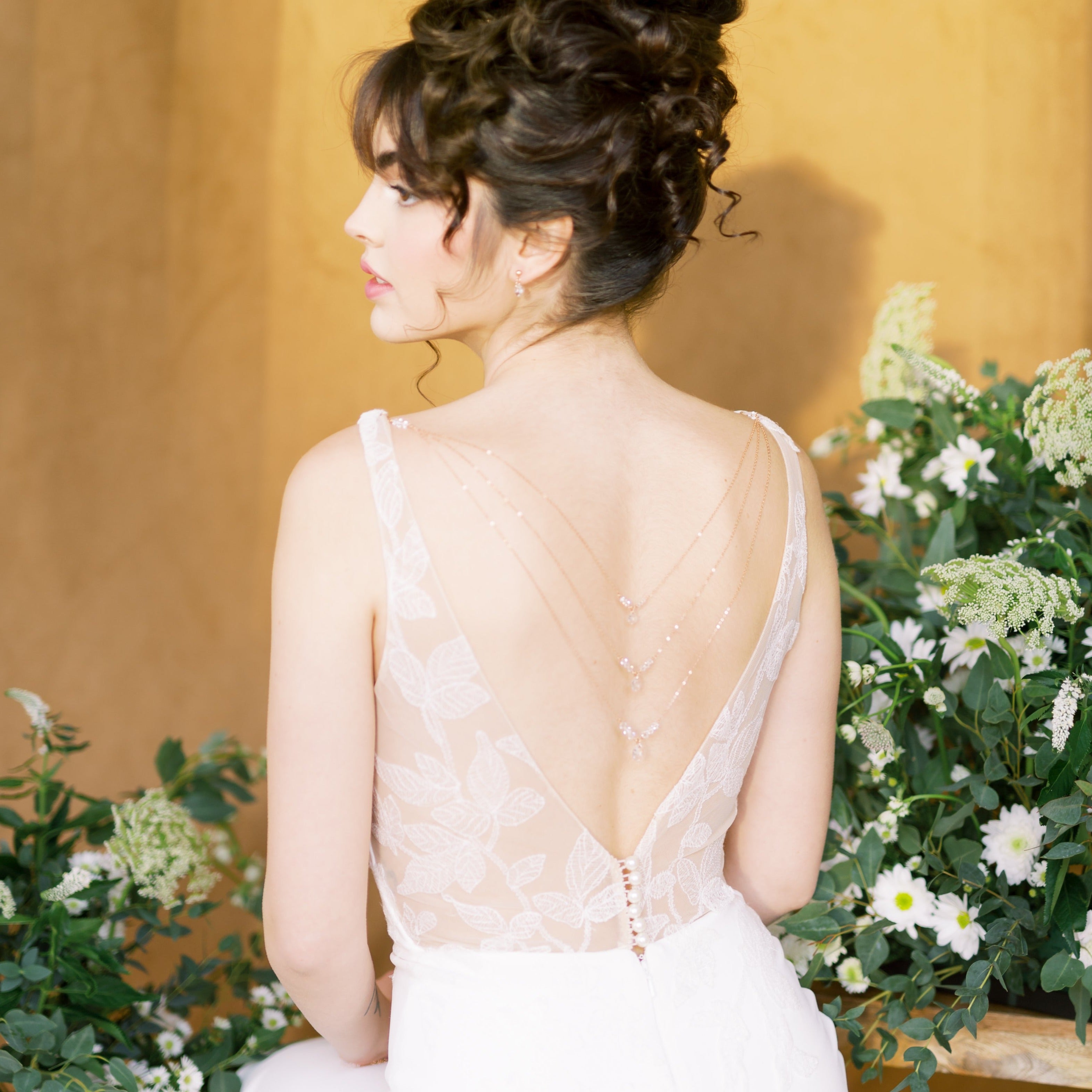 back necklace, earring & bracelet bridal jewelry set with clear crystals. Earrings are a tiny stud earring with a small crystal teardrop. Back necklace attaches to dress and has 3 tiers of crystal pendants. Bracelet has beaded bars of crystals. Available in silver, gold and rose gold. handmade in toronto canada by blair nadeau bridal adornments 