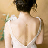long bridal back necklace with tiered pearls in graduated sizes. Back clasp is a round large statement clasp. Front necklace has a beaded bar of 3 round glass pearls. Available in gold, silver & rose gold with white, ivory, blush or iridescent pearls. handmade in toronto canada by blair nadeau bridal adornments