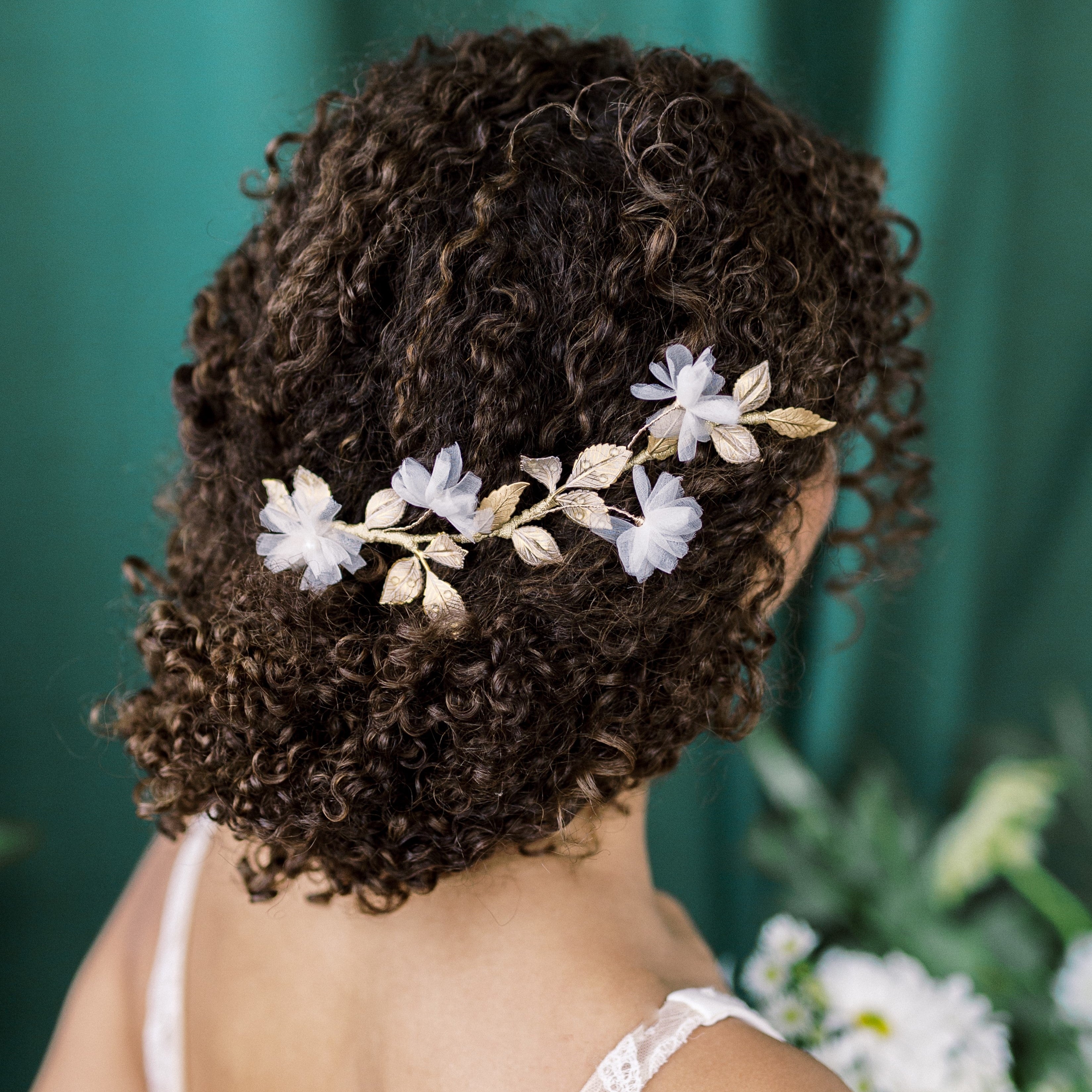 golden brass rose leaf hair vine with hand applied clear crystals on leaves to resemble dew drops.  Sprigs of silk flowers throughout vine. Ribbon wrapped with metallic ribbon. Finished on combs.  Made in Toronto Canada By Blair Nadeau Bridal Adornments