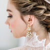 large statement art deco inspired bridal earrings with filigree medallions in two sizes. Available in brass, gold or silver finished with white or ivory pearls. These beautiful earrings sparkle with geniune crystals. 6mm crystal stud earrings. handmade in toronto ontario canada by blair nadeau bridal adornments photo by EC3 Moments