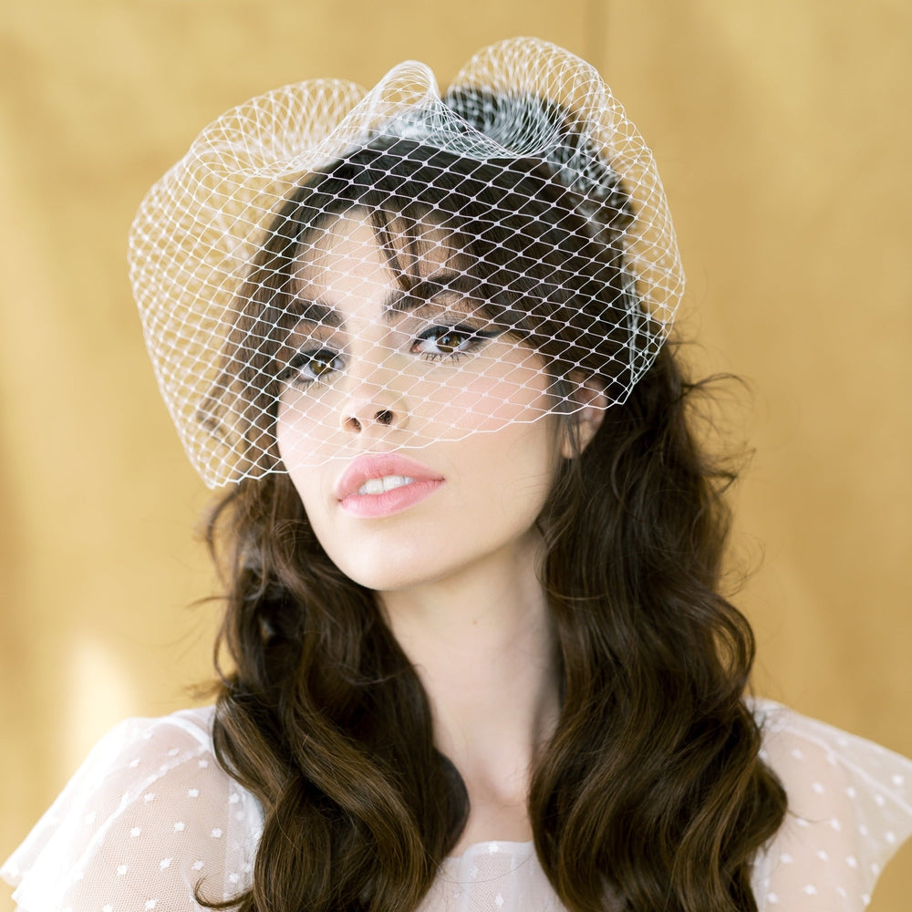 vintage inspired birdcage veil stitched with 3 combs for a perfect fit. The combs are all hand beaded with crystals or pearls. Available in ivory or pure white with clear or Aurora Borealis crystals or complimenting pearls. Handmade in Toronto Canada by Blair Nadeau Bridal Adornments