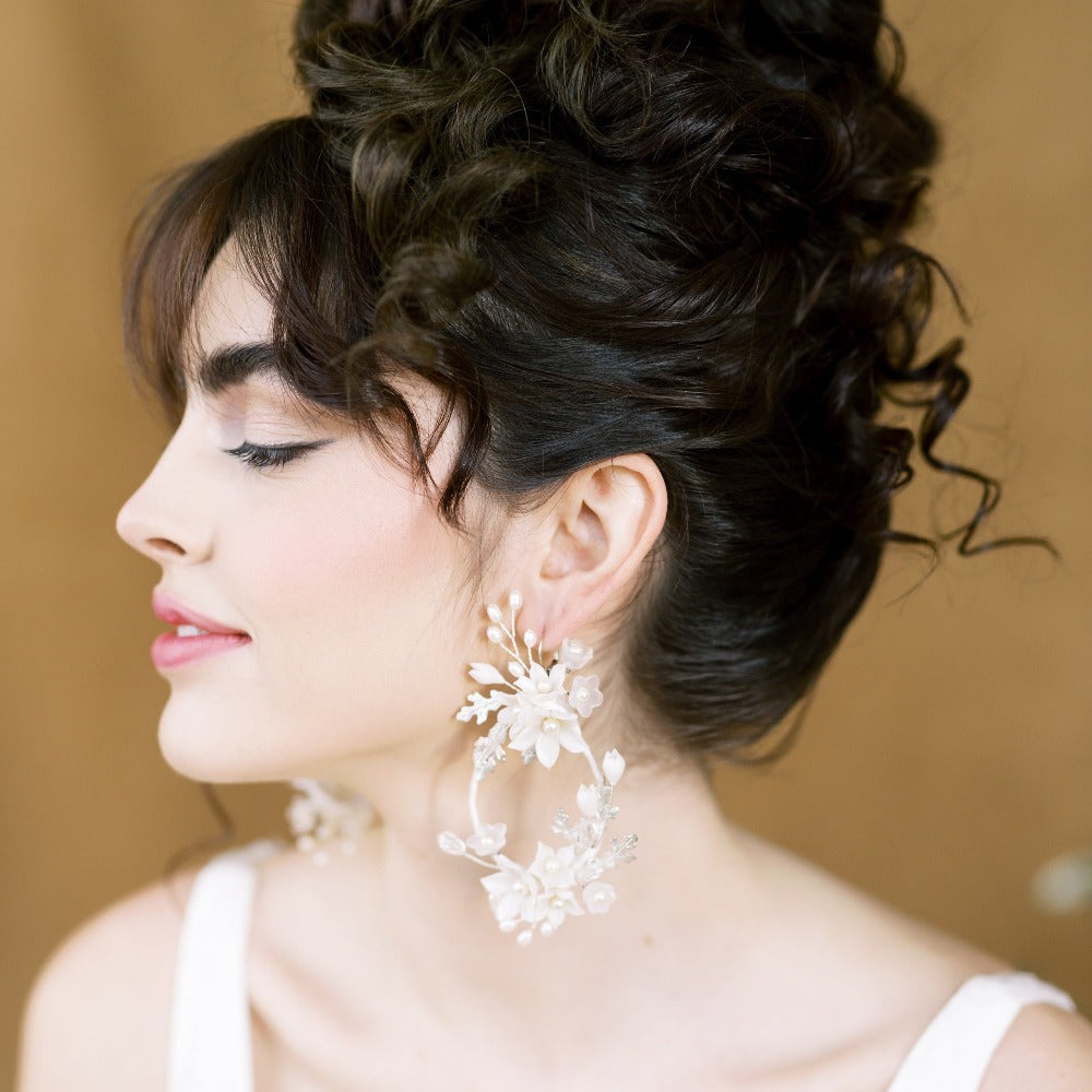 extra large teardrop earrings and wrapped in silk like ribbon and embellished with plated leaves, clay and lucite flowers and sprigs of freshwater pearls. linked to a plated brass ear wire. Available in off white and silver or gold. handmade in toronto canada by blair nadeau bridal adornments