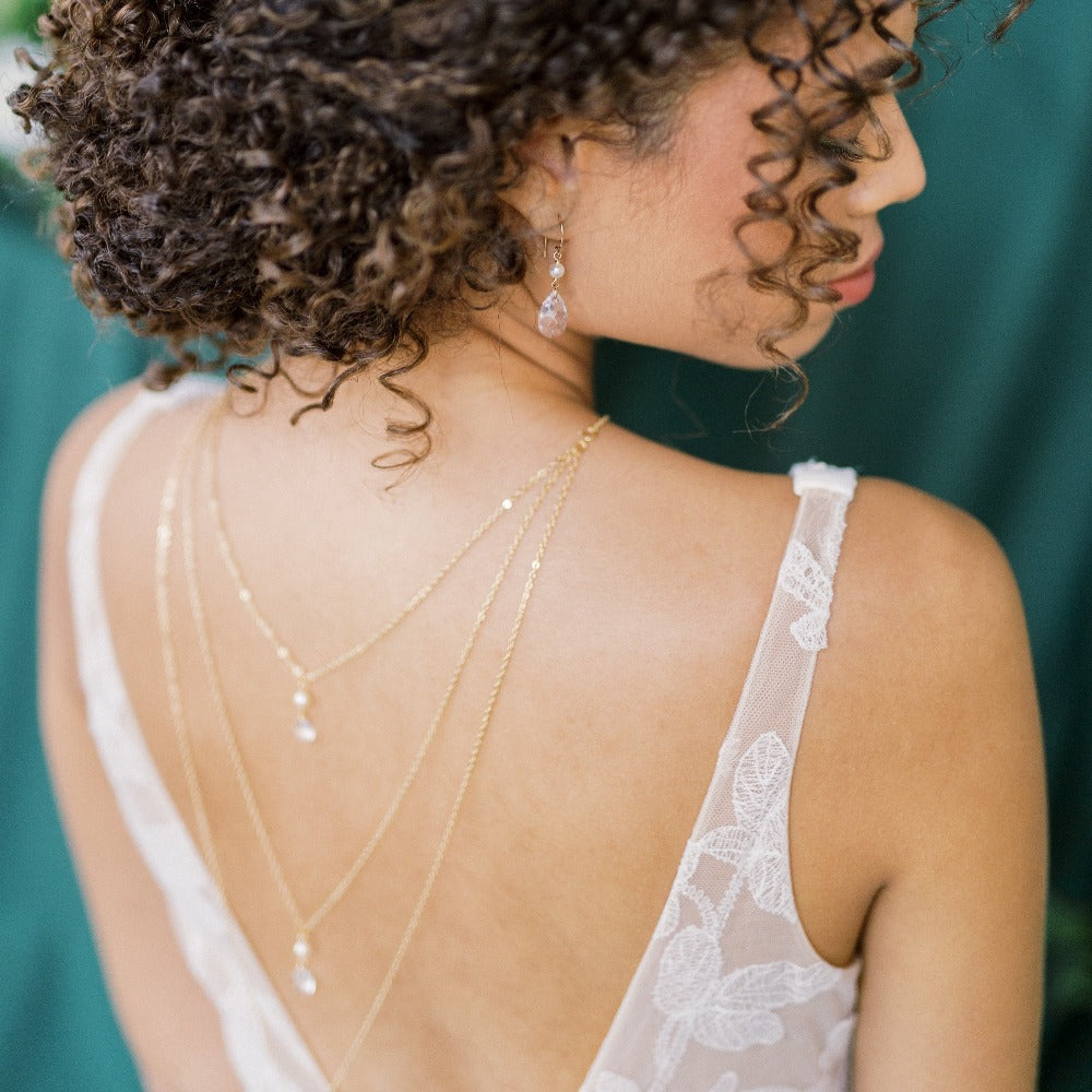 three tier layered crystal and pearl bridal back necklace with matching crystal and pearl earrings. Available in silver, gold and rose gold with white or ivory pearls. Handmade in Toronto Canada by Blair Nadeau Bridal Adornments